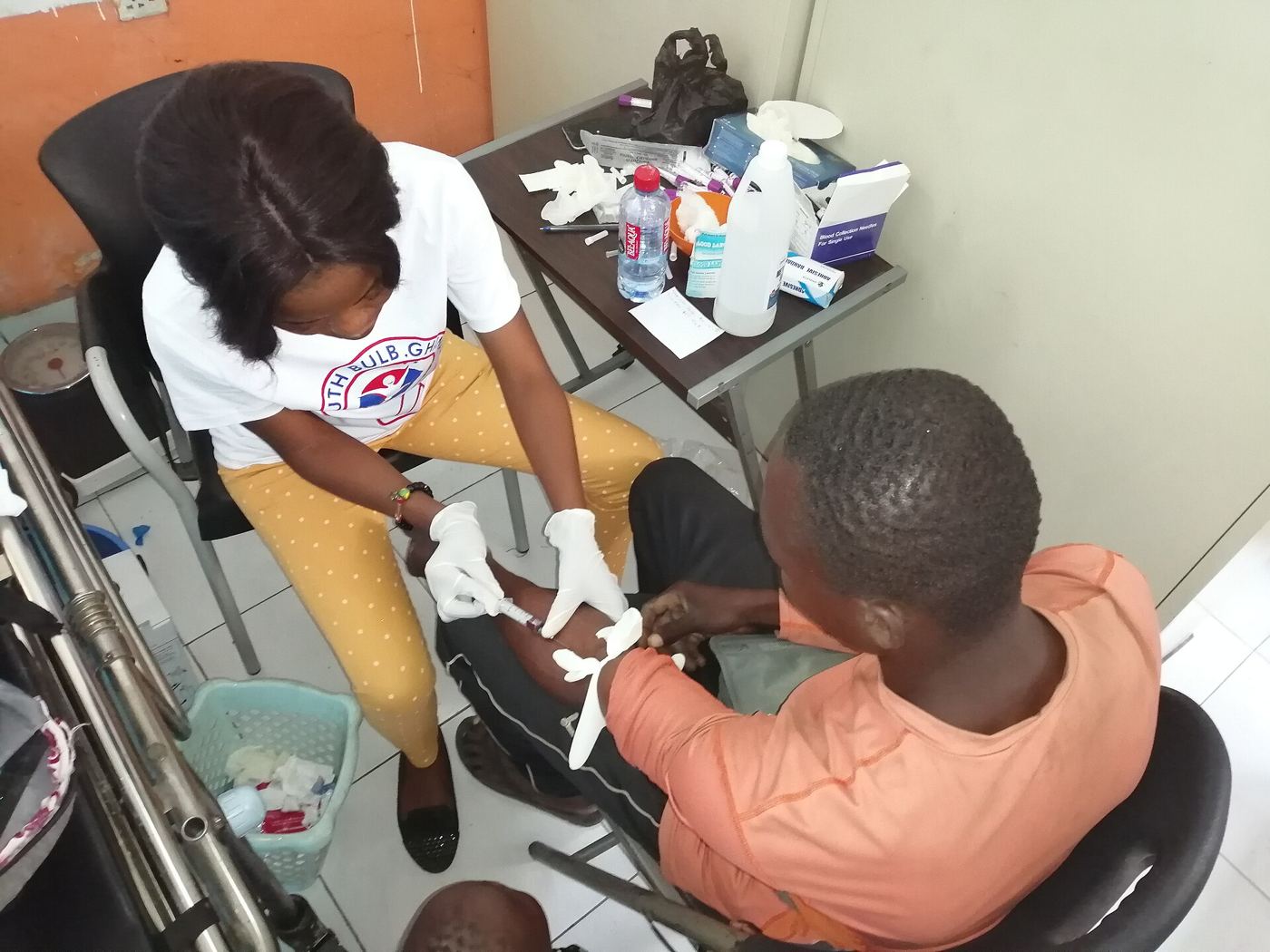 Photograph of a health worker preparing a vaccine dose at a community clinic.