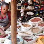 A trader using a mobile phone at an African market stall